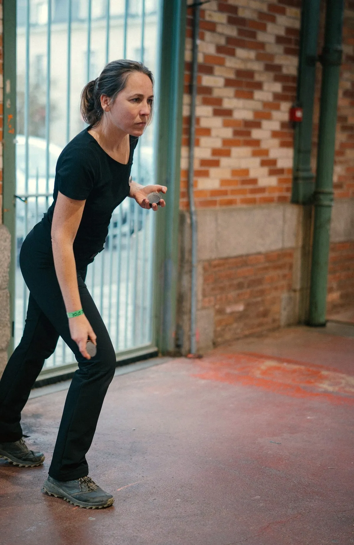 Une joueuse se concentre avant de lancer, devant les grilles de la Halle Martenot