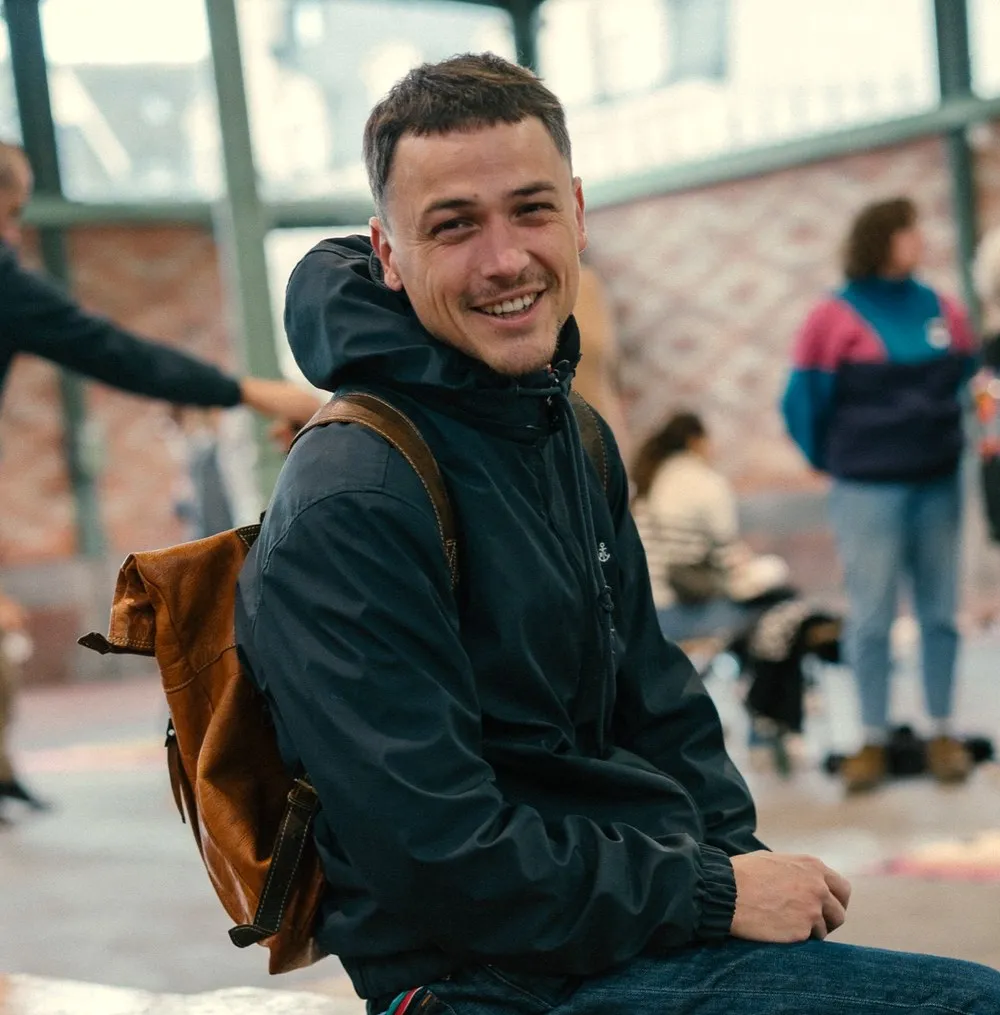 Un joueur sourit, assis sur un banc de la Halle Martenot